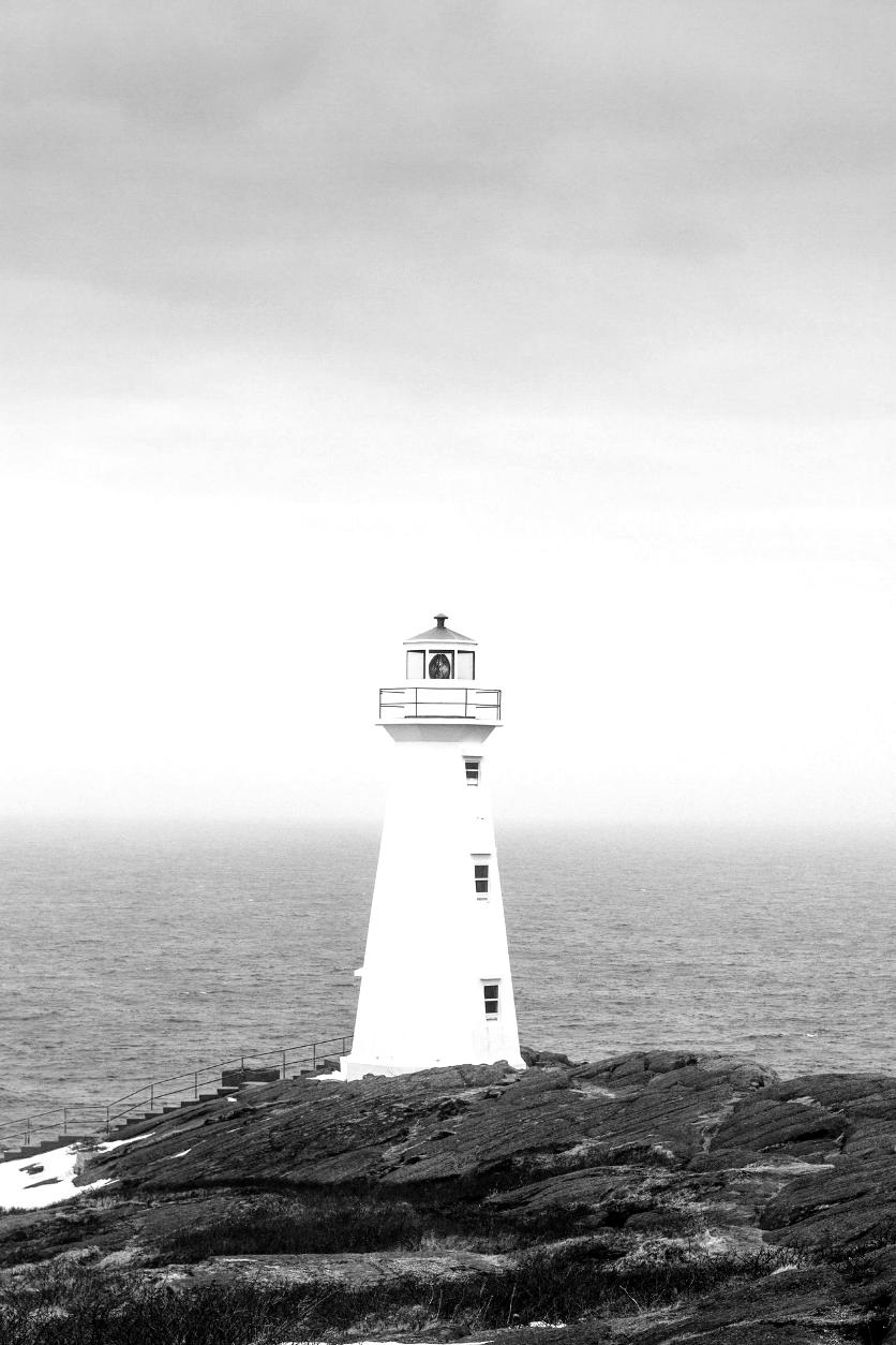 white lighthouse near body of water during daytime